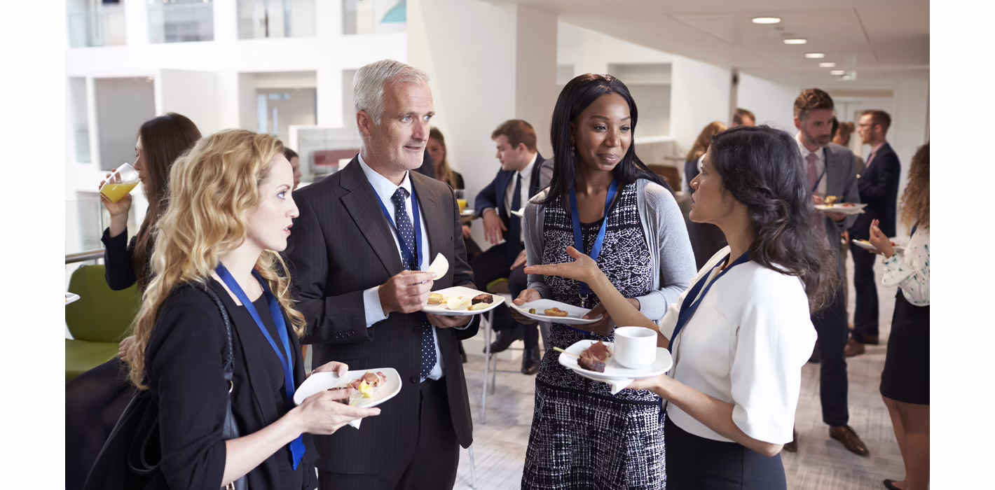 A group of people in business attire networking at a business event.